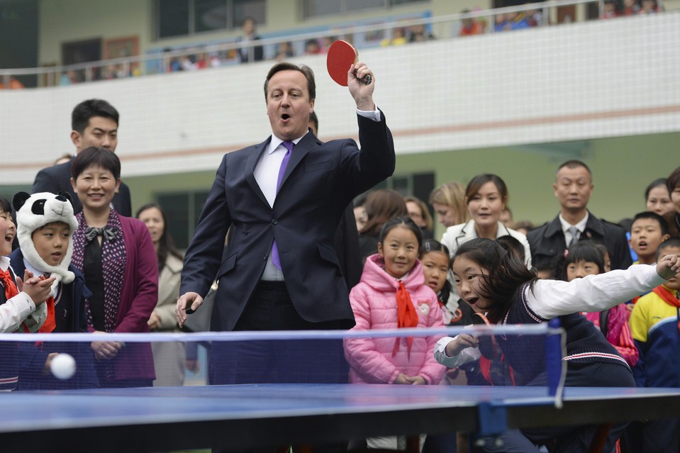 Британский премьер-министр Дэвид Кэмерон играет в пинг-понг в одной из школ города Чэнду. 
