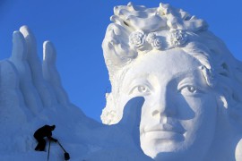 Рабочий делает снежную скульптуру на Харбинском международном фестивале льда и снега.
