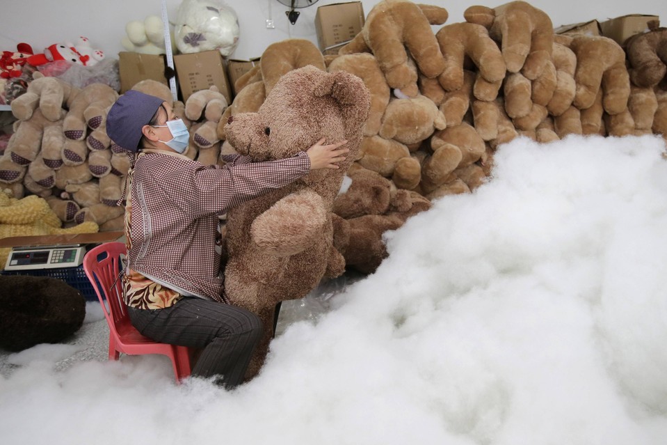 Женщина набивает мягкую игрушку на фабрике в Ухане