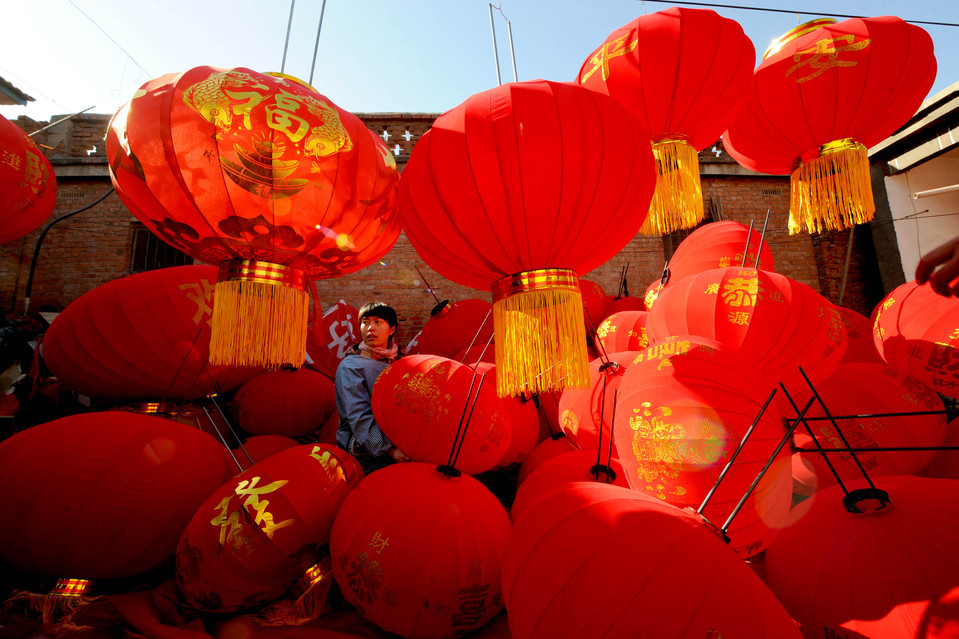 Житель деревни Сюйбэйчжан в провинции Хэнань готовится развешивать красные фонарики в преддверии празднования Китайского нового года. Фото: Zuma Press