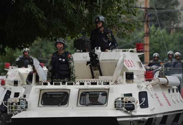 Китайская военизированная полиция на улицах Урумчи. Военные и техника были введены в Синьцзян после беспорядков, произошедших в июне 2013 года. Фото: AFP/Mark Ralston
