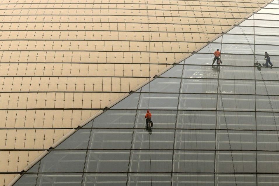 Рабочие моют окна Национального центра исполнительских искусств в Пекине. В народе за форму его прозвали "Яйцом". 