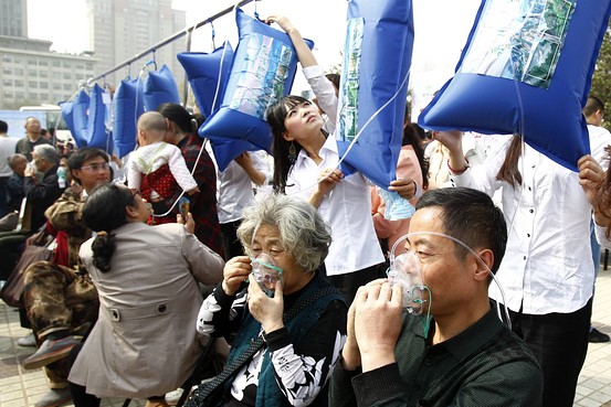 Жители города Чжэнчжоу дышат горным воздухом из пакетов. Фото: Reuters