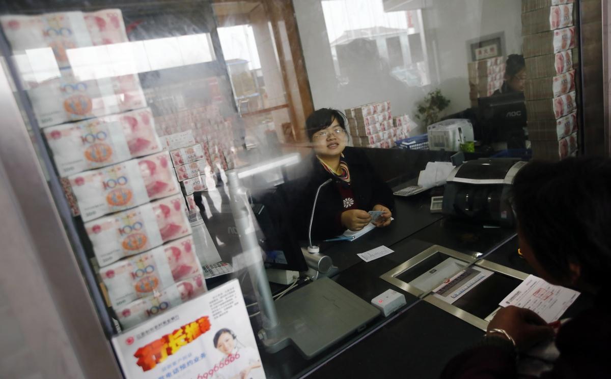В китайском городе Яньчэн (провинция Цзянсу) сотрудники банка Sheyang выставили на всеобщее обозрение пачки денег, чтобы успокоить вкладчиков, напуганных слухами о том, что местные банки испытывают проблемы с наличностью. Фото: Reuters