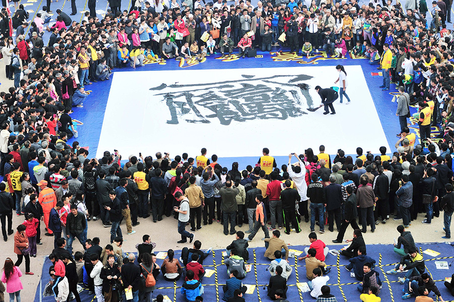 Каллиграф Сюй Сяодун пишет на листе бумаги площадью 100 кв. метров иероглиф   "BIANG". Сиань, провинция Шэньси. Фото: Юань Цзинчжи/Синьхуа