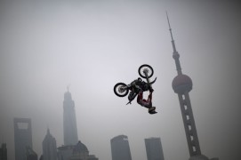 Австралийский мотоциклист Майкл Норрис во время показательных выступлений на набережной в Шанхае в честь начала Всемирных экстремальных игр