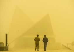 Двое мужчин идут по улице во время песчаной бури в Кашгаре, Синьцзян-уйгурский автономный район. Порывы ветра достигали скорости 120 километров в час, а видимость снизилась до 20 метров. Последний раз песчаная бура такой разрушительной силы была в стране в 1996 году.
