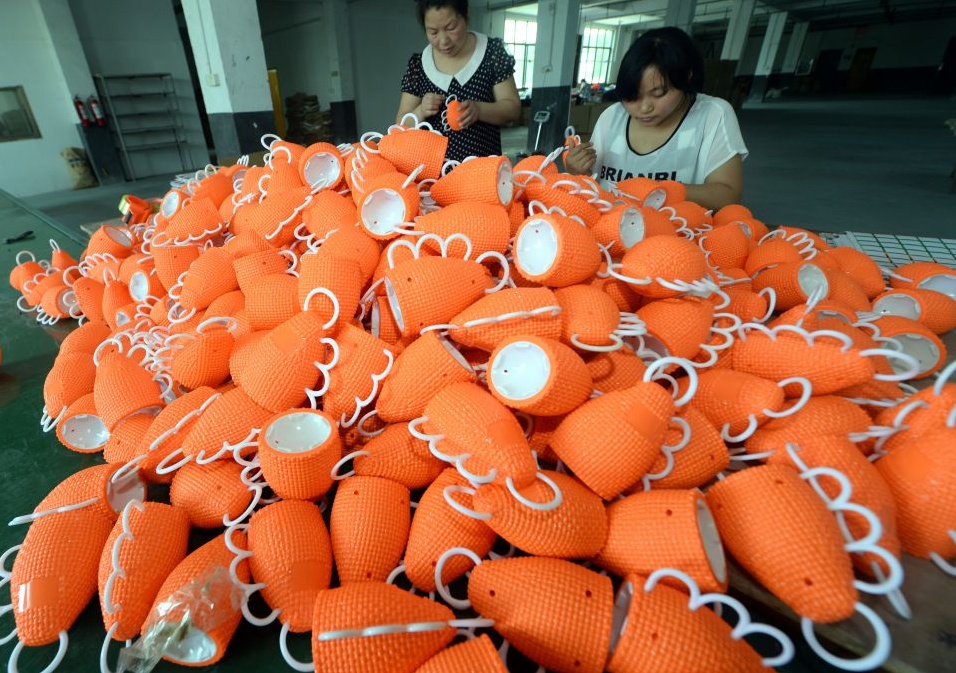 Работницы на фабрике в провинции Чжэцзян делают каширолы, официальные музыкальные инструменты чемпионата мира 2014 года по футболу в Бразилии. 