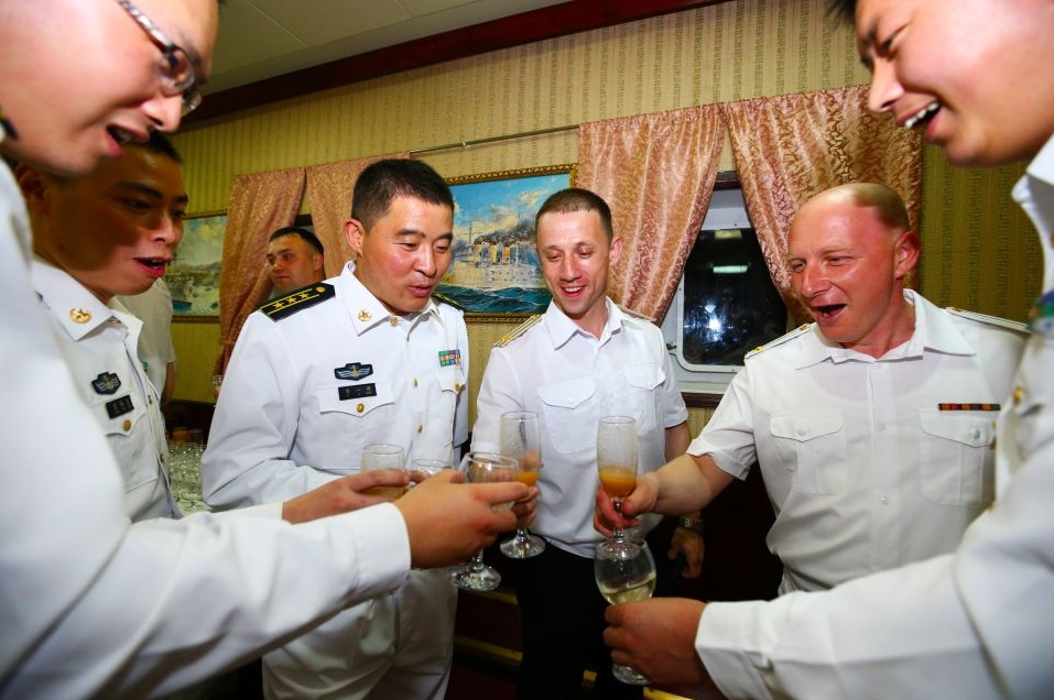 Российские и китайские офицеры во время приема, организованного на российском ракетном крейсере "Варяг" в Шанхае. Суда Тихоокеанского флота России прибыли в Китай для совместных учений.