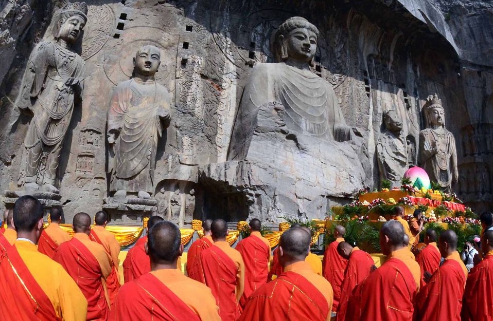 Буддийские монахи в гротах Longmen, провинция Хэнань.