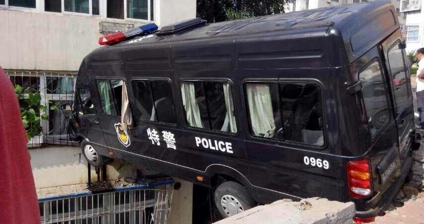 Автомобиль полицейского отряда особого назначения, вылетевший с дороги и застрявший между зданием и бетонным выступом на высоте 3-го этажа, провинция Шаньдун.