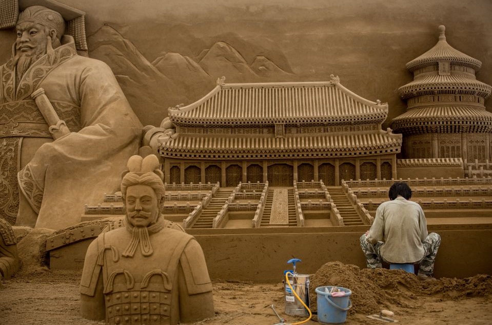 Китайский скульптор Чжан Вэйкан работает на выставке песчаных скульптур в Иокогаме, Япония.