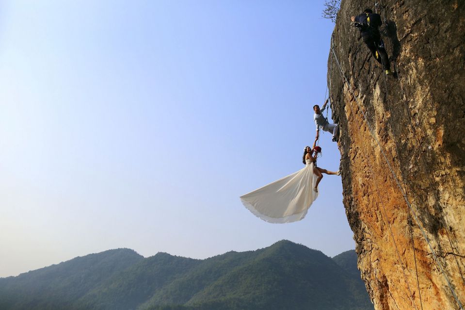 Скалолаз-любитель Чжэн Фэн и его невеста делают свадебные фотографии, провинция Чжэцзян.  