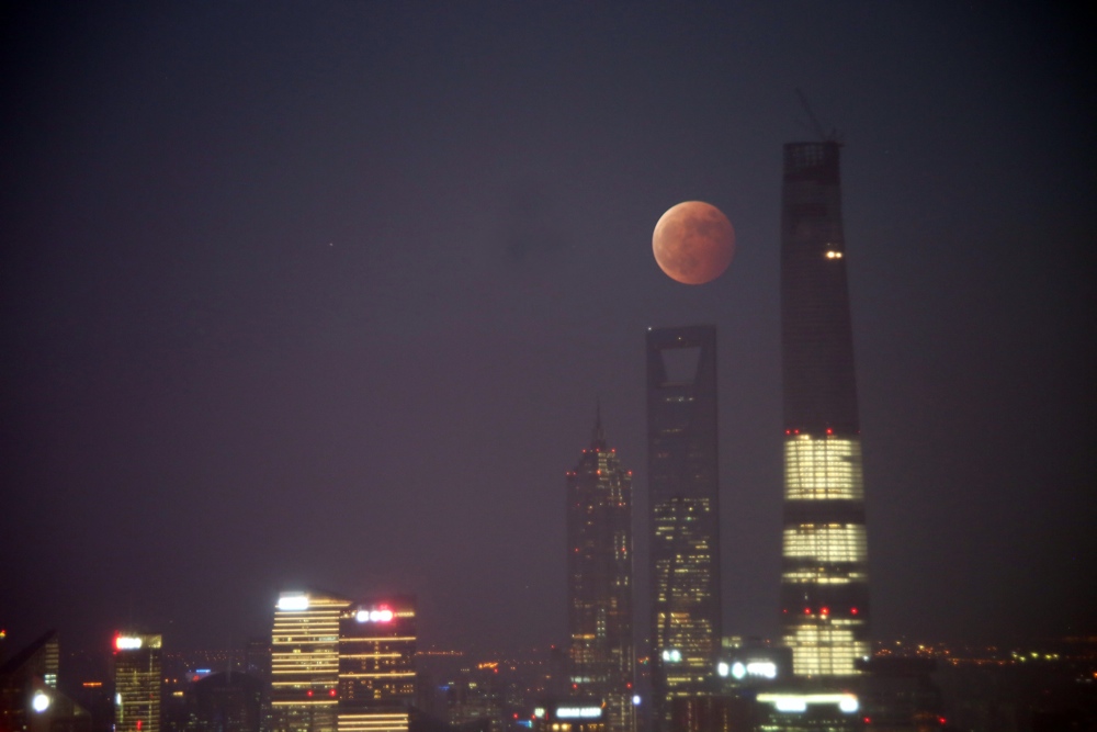 «Кровавая Луна» над Шанхаем. 8 октября жители Китая могли наблюдать полное лунное затмение, которое в совпало с заходом солнца, что придало такой цвет Луне.