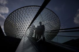 Люди на эскалаторе на фоне Expo Axis в Шанхае, крупнейшей в мире мембранной крыши.
