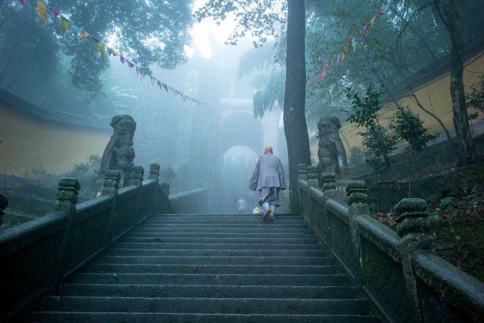 Монах поднимается по ступеням в храме на горе Цзюхуашань, одной из четырёх священных гор китайского буддизма, провинция Аньхой.