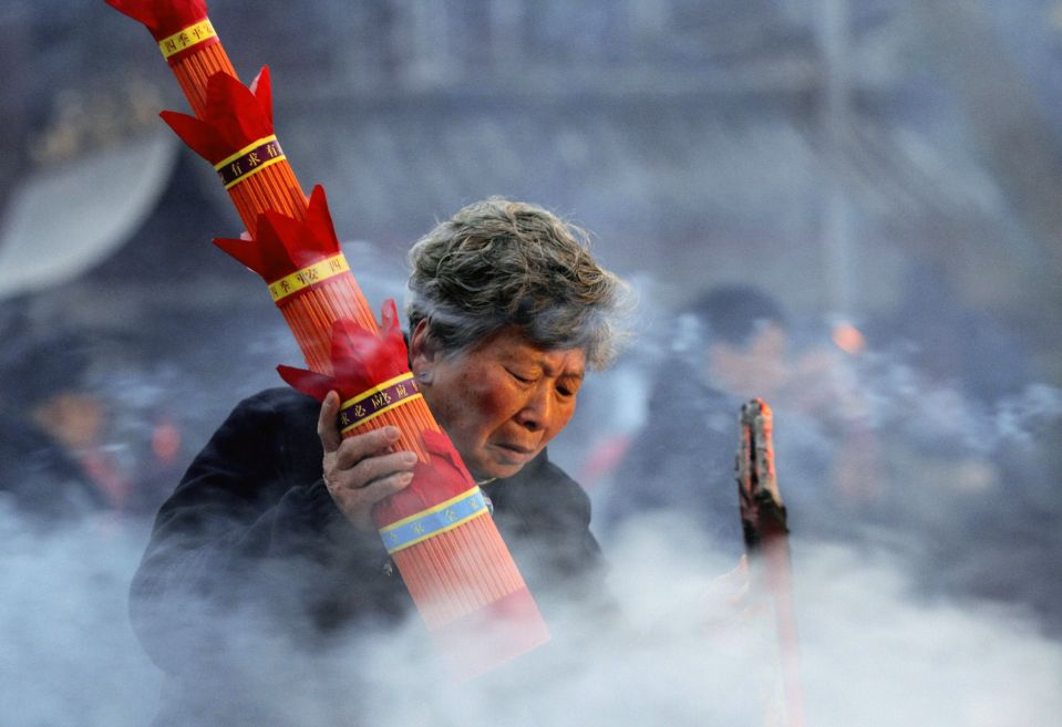 Женщина в буддийском храме в городе Хуайань, провинция Цзянсу. Китай отмечает праздник Лаба, который в этом году выпал на 28 января. Это своеобразная прелюдия ко встрече китайского Нового года. 