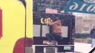 Китаец едет прицепившись сзади ка автобусу