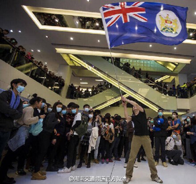Протестующий размахивает колониальным флагом Гонконга. Фото: weibo