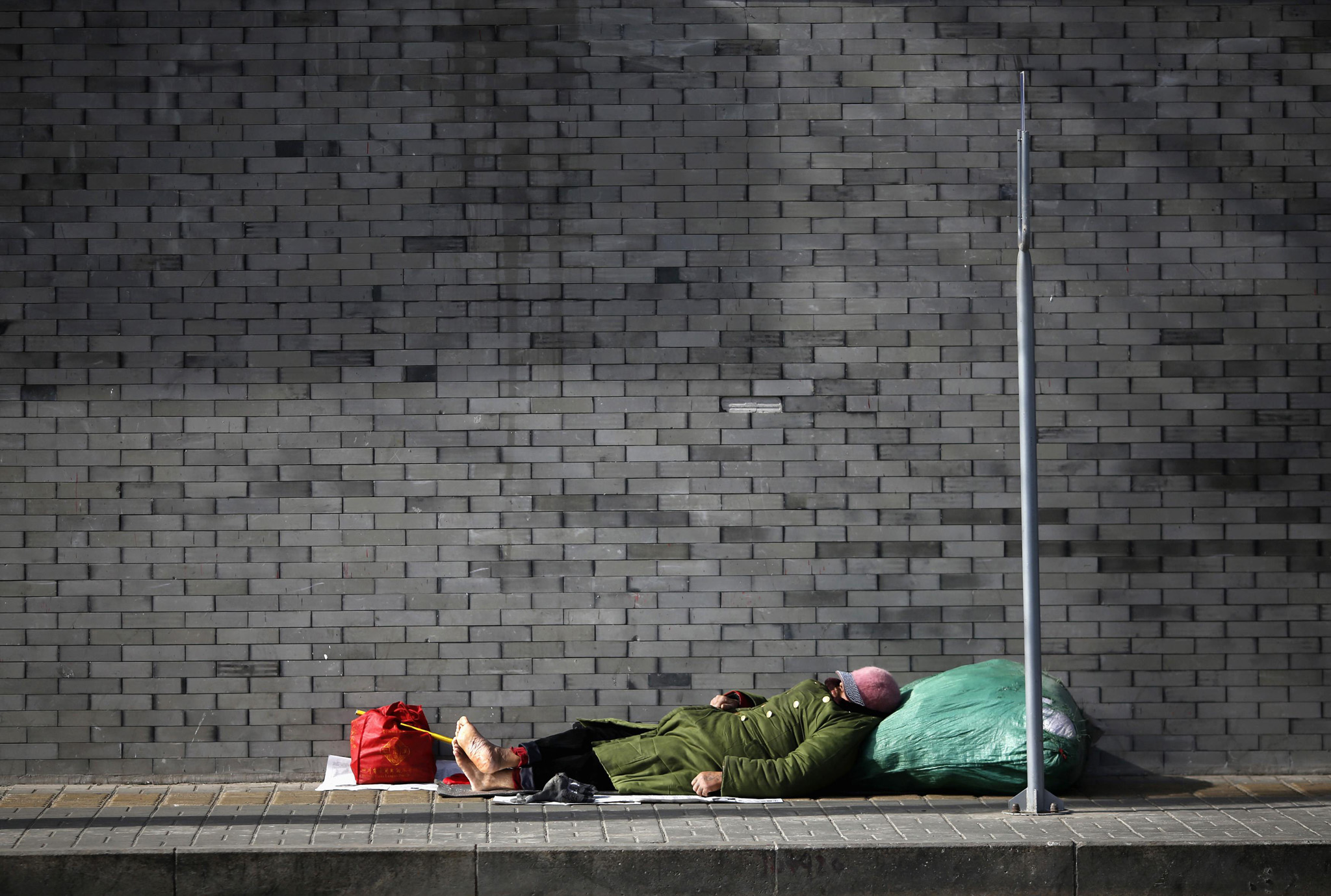 Мужчина спит на улице в Пекине.