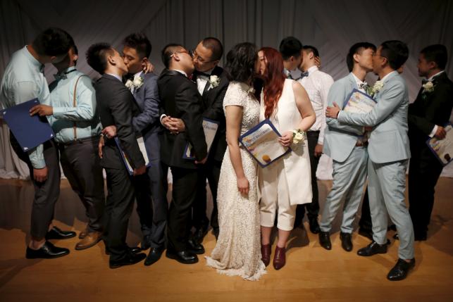 Молодожены целуются после церемонии бракосочетания 7 однополых пар из КНР в Калифорнии. 