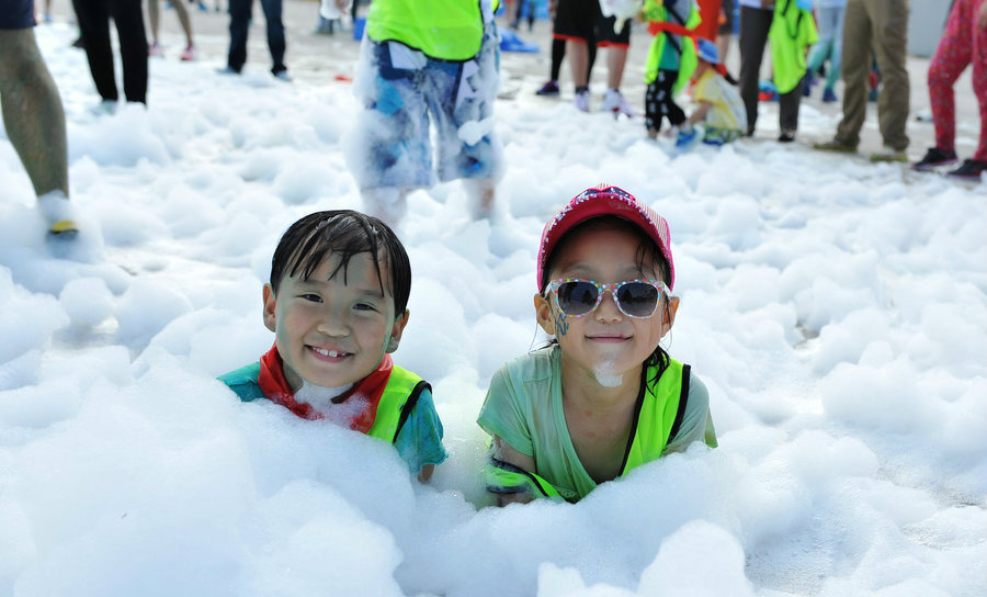 Дети веселятся во время Пенного забега (Bubble Run) в городе Шэньян провинции Ляонин.