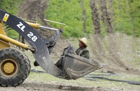 Рабочий катается в ковше экскаватора на стройплощадке горнолыжного склона курорта Wanlong Ski Resort в провинции Хэбэй. Китай надеется, что там пройдут Зимние Олимпийские Игры 2022 года.