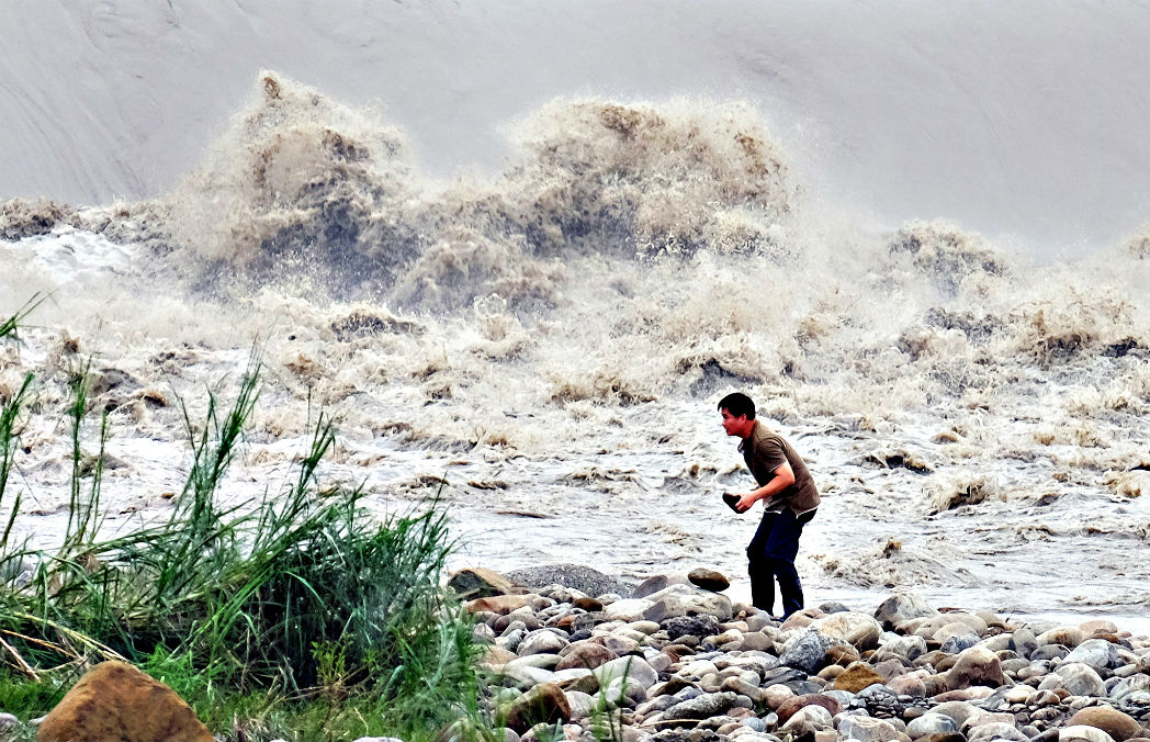 Житель Тайваня собирает камни на реке Синьдянь после прихода мощного тайфуна Ду-Цюань 29 сентября. 