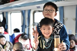 Пассажиры поезда Гуанчжоу—Чэнду, девятилетний Ван Цзяхуэй и шестилетний Ван Цзяжуй показывают электробритву, которую везут в подарок дедушке на китайский Новый год .