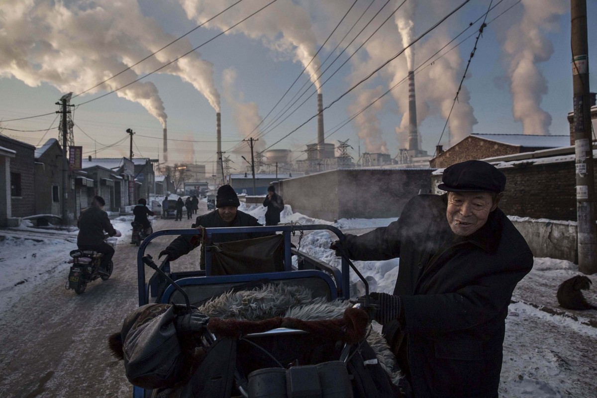 Рабочие толкают тележку на фоне работающей угольной электростанции в провинции Шаньси. Этот снимок выиграл первый приз в номинации «Повседневная жизнь/одиночное фото» на World Press Photo Awards.