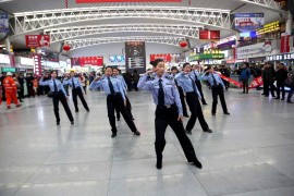 Полицейские танцуют на железнодорожной станции города Шэньян в рамках флэшмоба, который призывает пассажиров соблюдать осторожность в дни Праздника весны из-за повышенного пассажиропотока. Фото: ChinaFotoPress/Getty Images