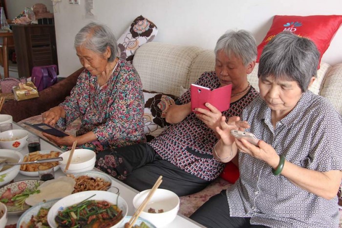 Три пожилые женщины делятся фотографиями своего обеда в WeChat. Фото:  VCG