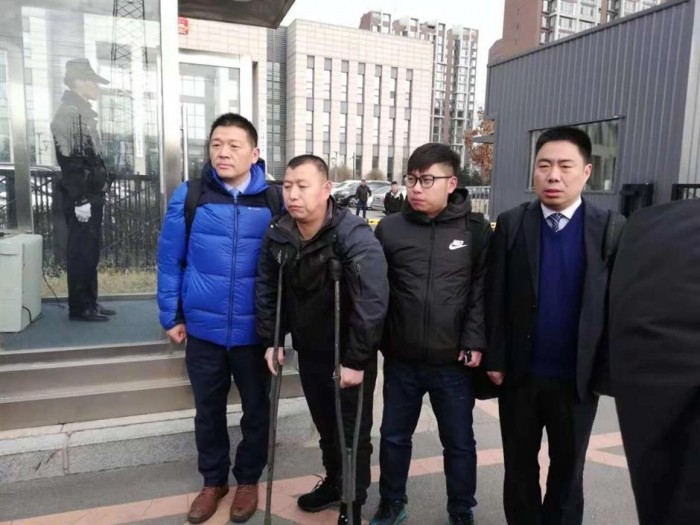 Цзинь Чжэхун (второй слева) у здания суда после освобождения 30 ноября 2018 г.  Фото: Синьхуа