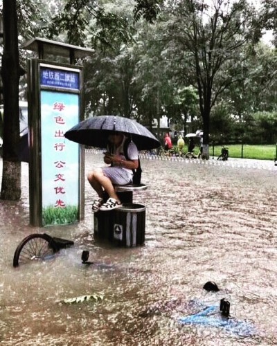китаец спасается от проливного дождя