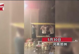 В Китае дождь не помешал друзьям продолжить застолье на улице. Их спасла картонка