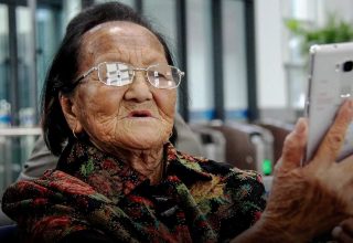 В Китае 94-летнюю бабушку пришлось держать на руках для активации карты в банке