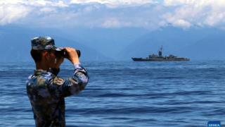 Китайский солдат наблюдает за тайваньским военным кораблем в беспрецедентной близости к острову