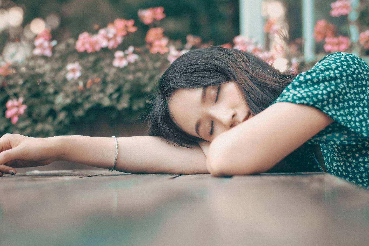 китаянка уснула на фоне цветов